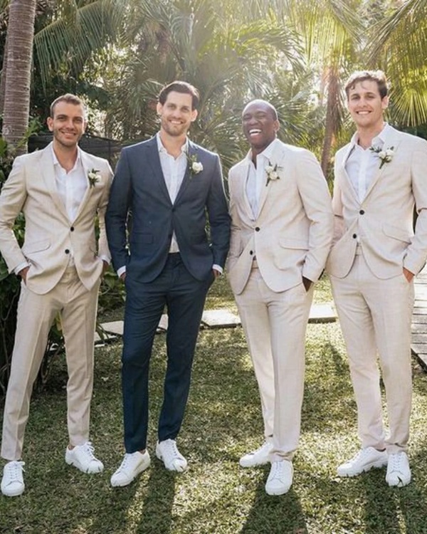 Bring the oceanic vibes to life with a stunning blue beach attire for the groom and beige for groomsmen for the ultimate beach wedding aesthetic.