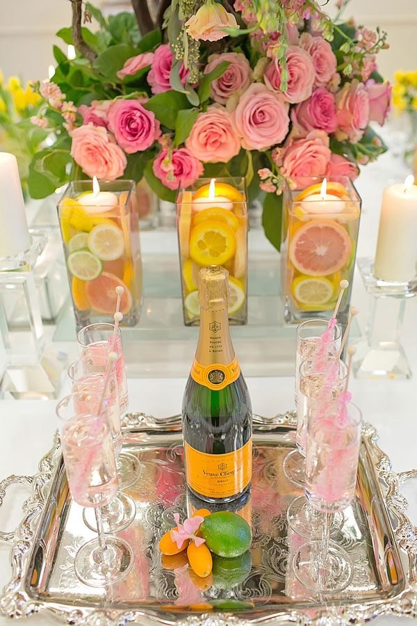 Decorate your wedding reception tables with these beautiful floating candle centerpiece ideas complete with bright orange and lemon slices.