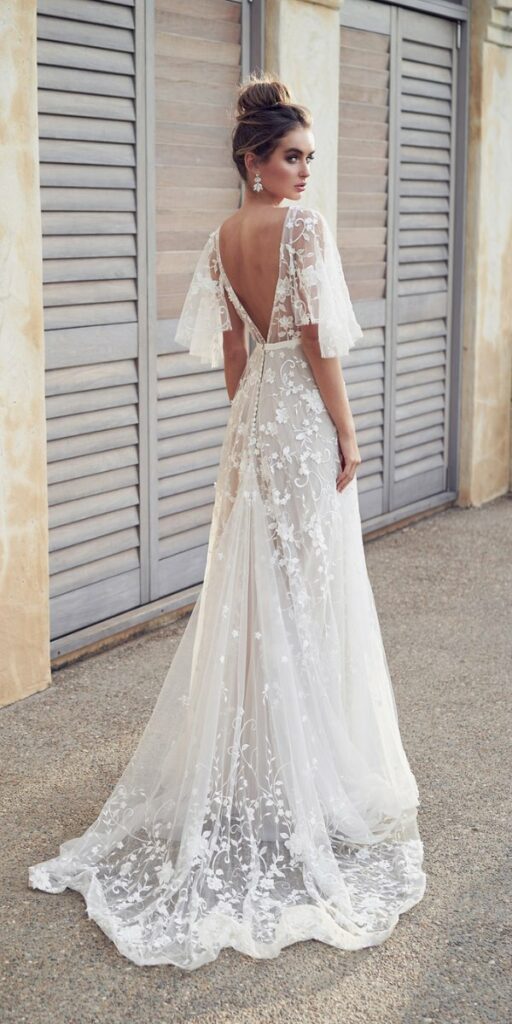 Embroidered tulle and draped sleeves characterize this boho dress for the beach wedding.