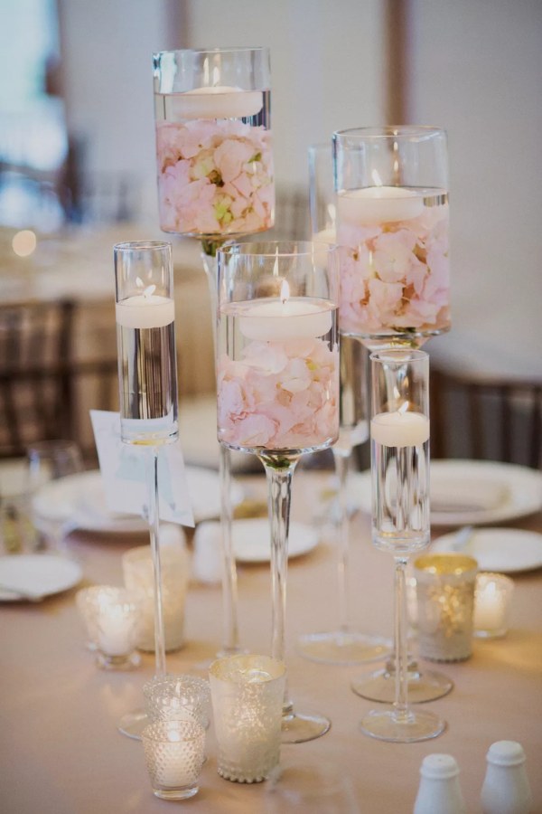 Ideas for floating candle centerpieces for weddings include candles and rose petals that are both modern and romantic.