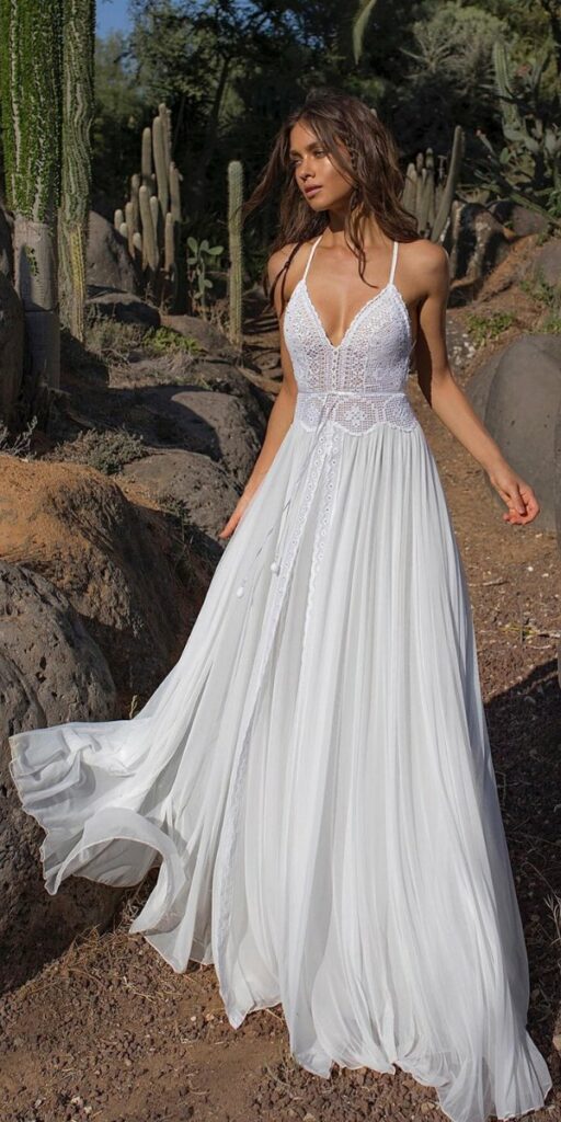 The straps crochet lace and eyelet accents on this softly boho beach wedding dress draw attention to the bodices.
