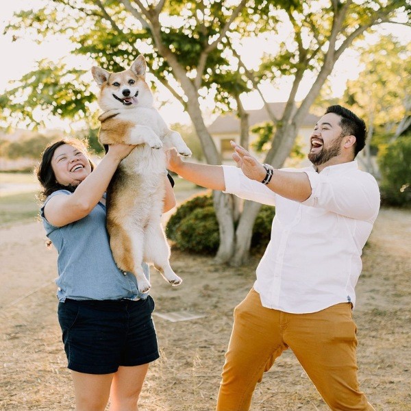 An adorable engagement photograph of a caring and loving couple and their trusty beloved dog
