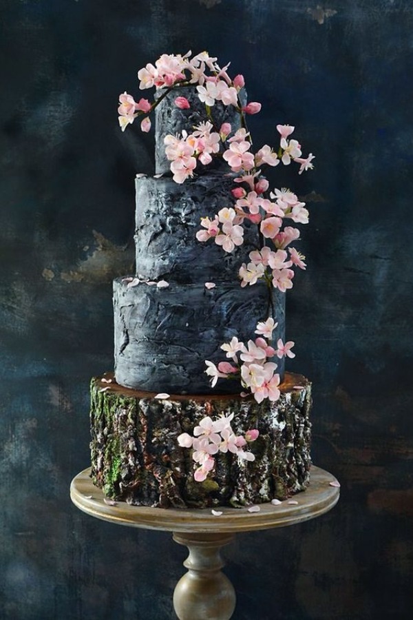 Black cake decorated with romantic pink roses in a woodsy style