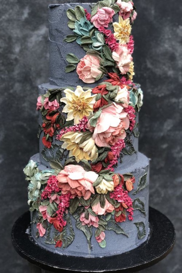 Buttercream black wedding cake topped with romantic flowers