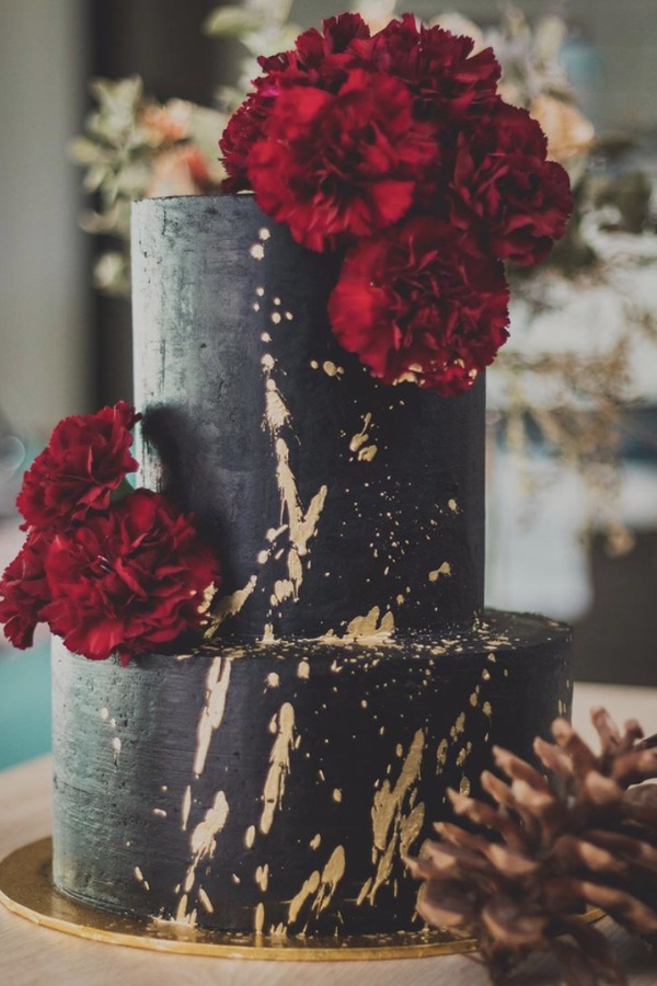 This elegant black wedding cake with gold splatter is stunning. The bright red color provides an attractive contrast to the black buttercream