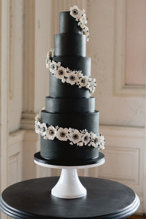piping dozens of intricate white rosettes onto your black wedding cake