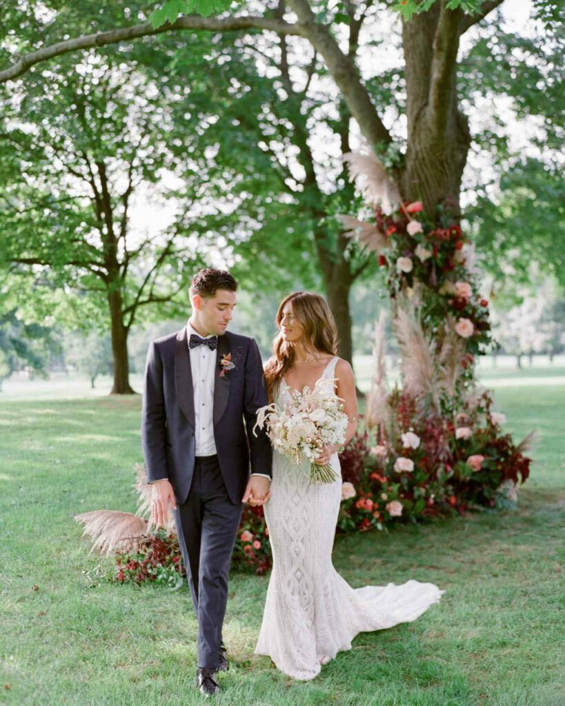 groom and bride in boho theme wedding dresses and romantic bouquet