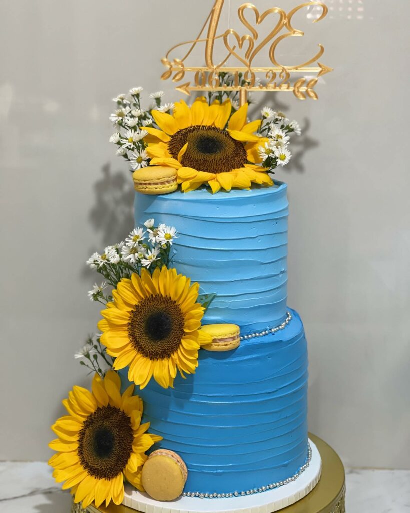 blue textured sunflower and macaron wedding cake