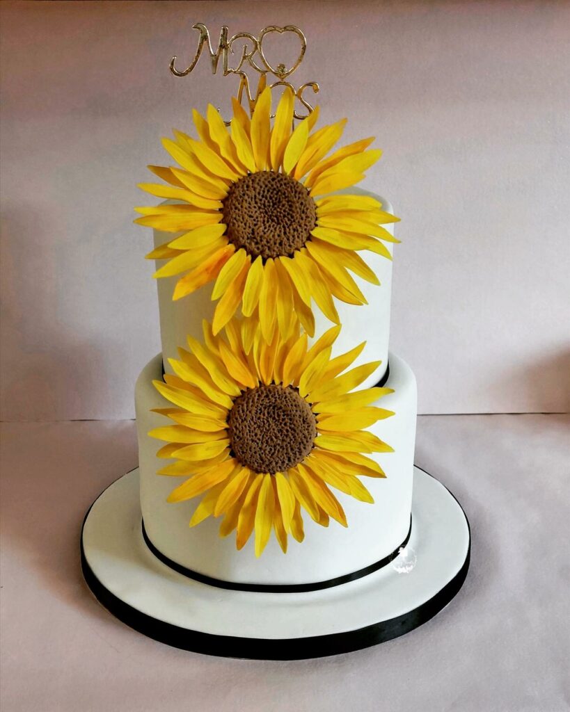 elegant sunflower two tiered wedding cake with toppers