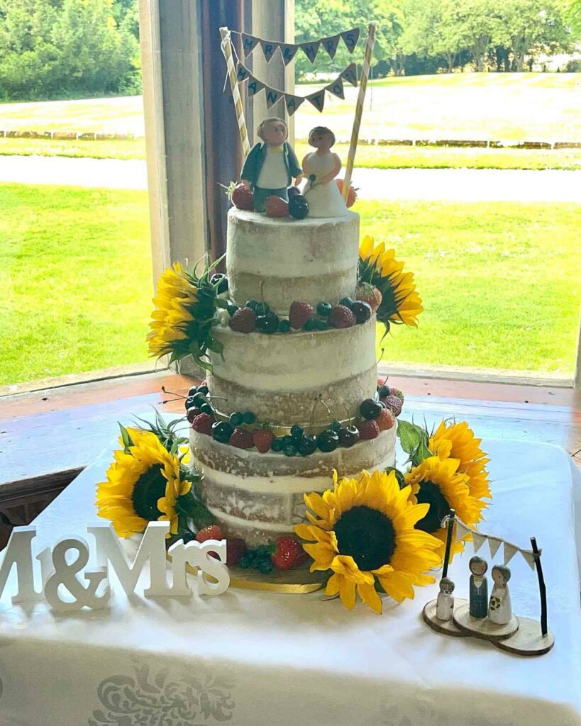 naked sunflower wedding cake with berries