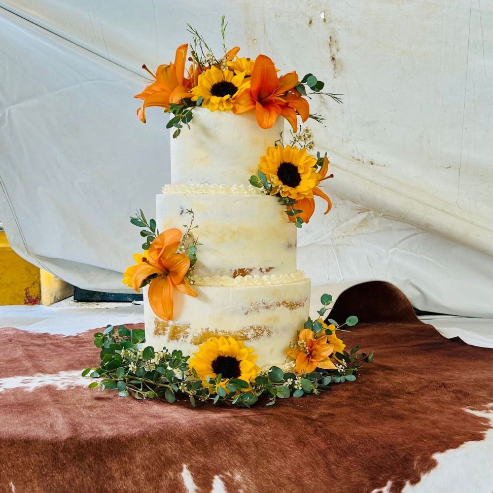 orange lilies and sunflower rustic inspired wedding cake