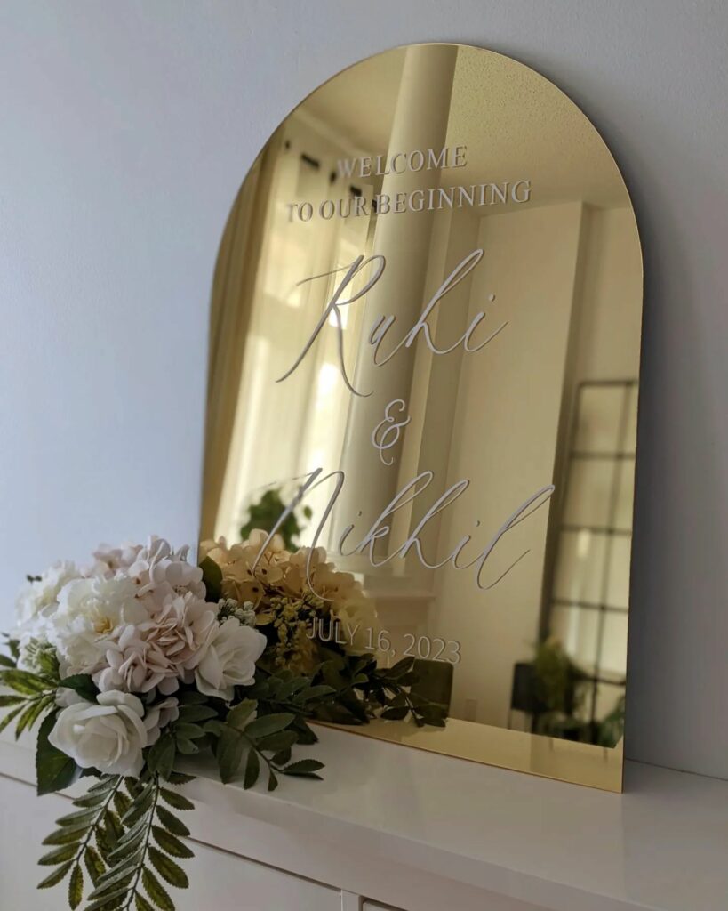 a gold mirror acrylic arch wedding welcome sign