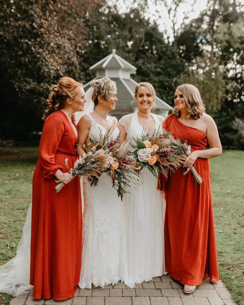 brides with red gown bridesmaid for lesbian autumnal wedding