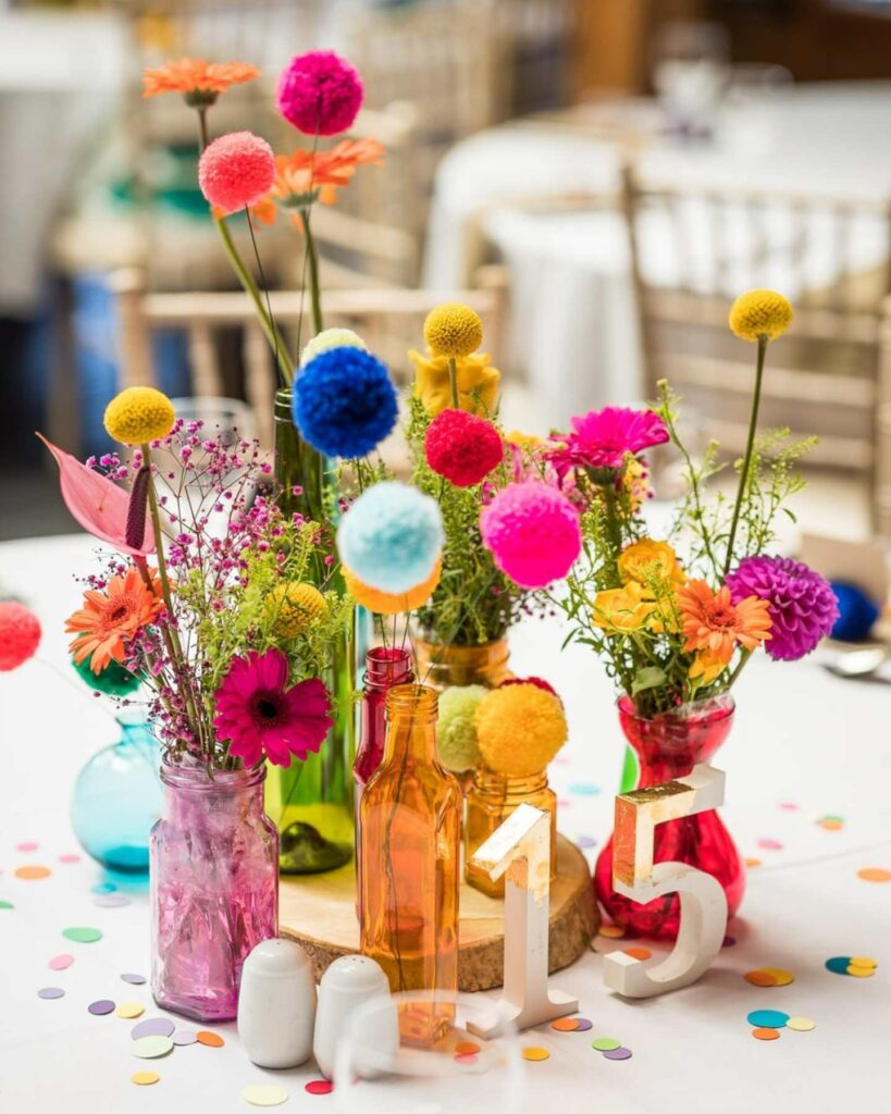 colorful rainbow themed lesbian wedding centerpiece decorations with pom poms