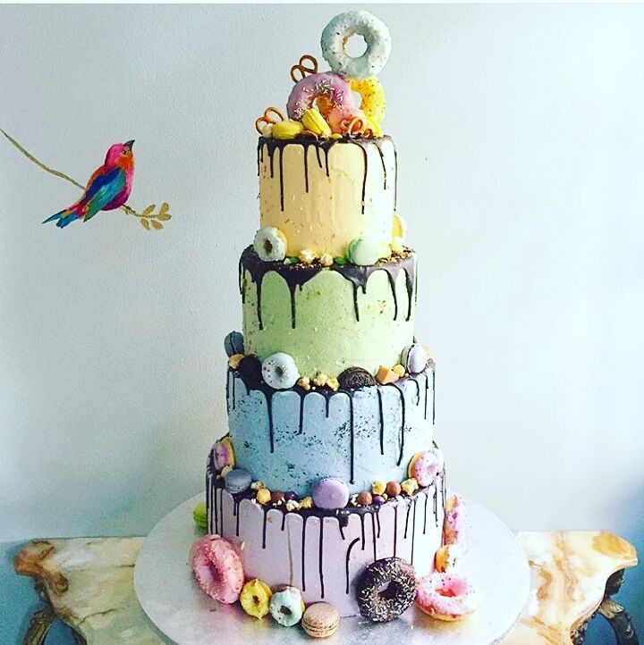 delicious four tiered rainbow cake with doughnuts for same sex wedding