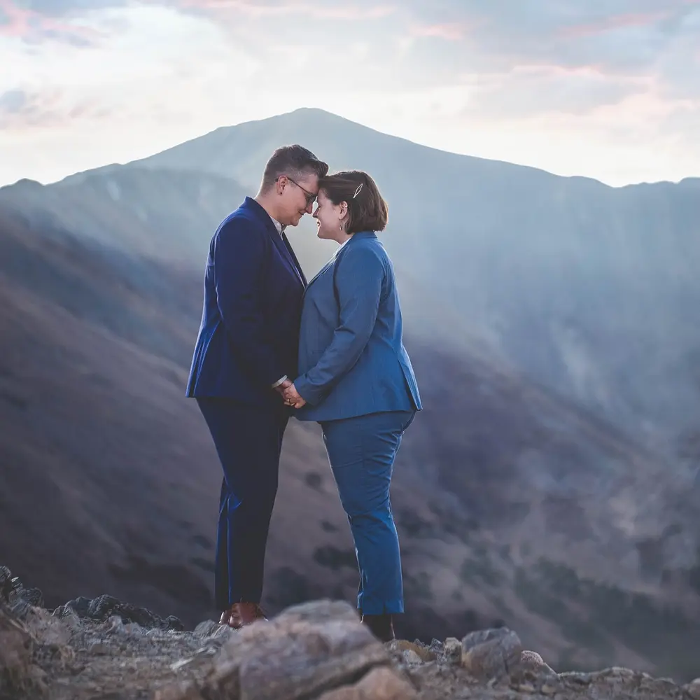 lesbian blue wedding outfit stands out against the mountains