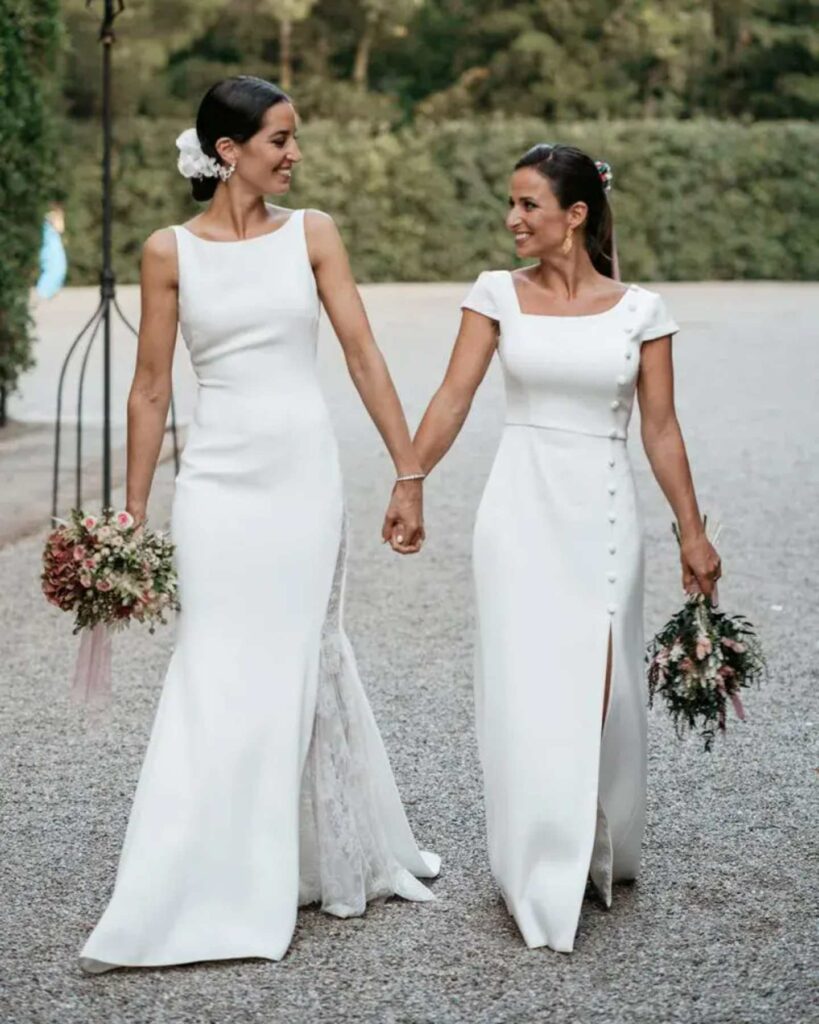 lesbian brides in fitted same sex wedding dress with bouquet