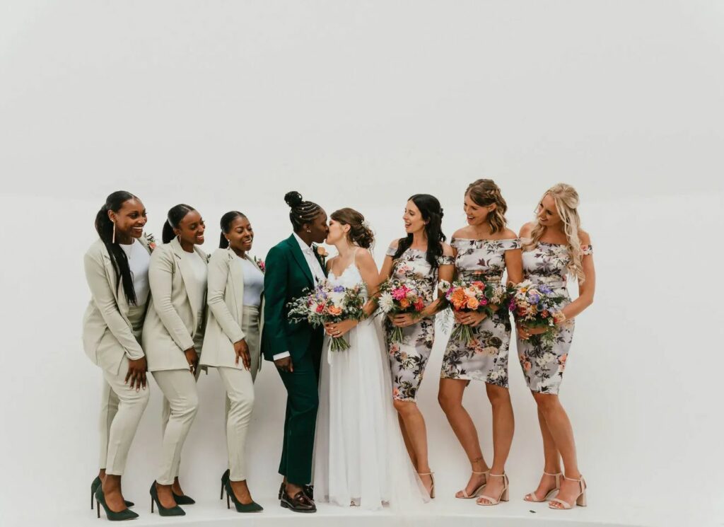 lesbian wedding couple surrounded by their cherished wedding party