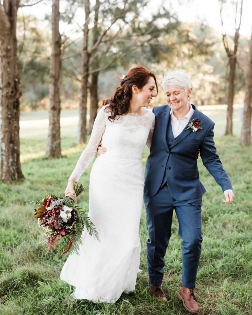 lesbian wedding outfits in navy blue suit paint and gorgeous white gown with bouquet