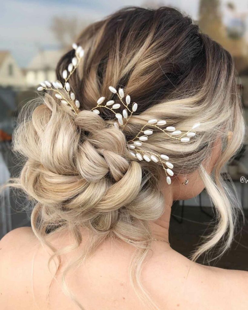 messy braided wedding updo with hair accessory