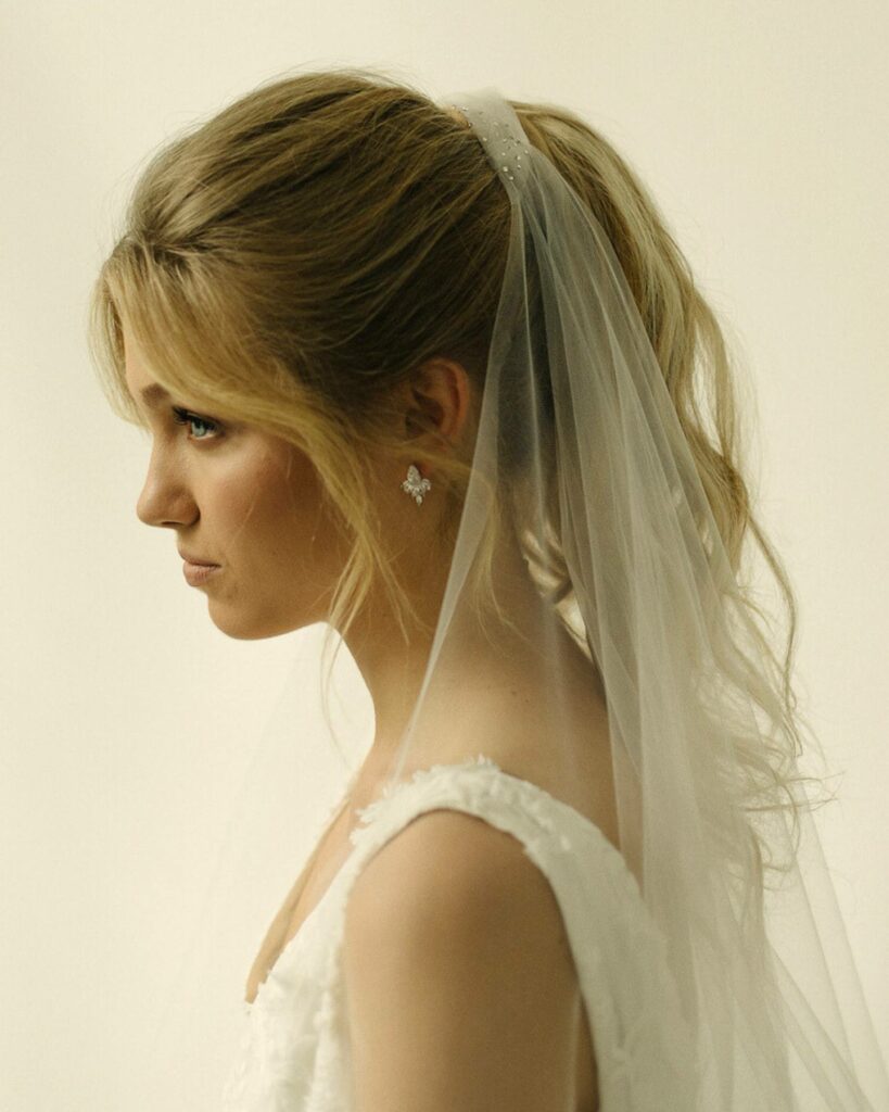 ponytail thin wedding hairstyle with fingertip veil