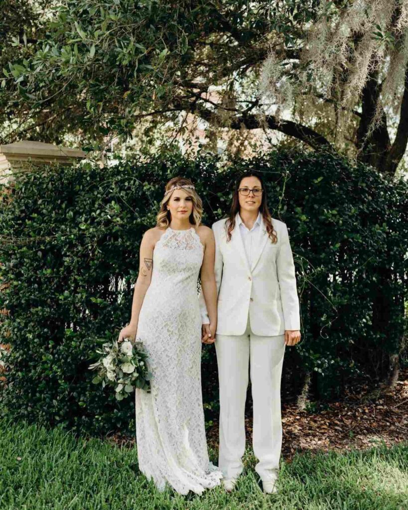 pretty lesbian brides in white gown and suit for outdoor wedding