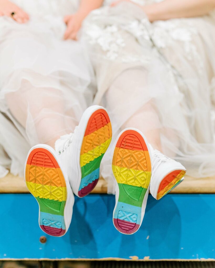 pride lesbian brides with pair of sneakers and rainbow soles