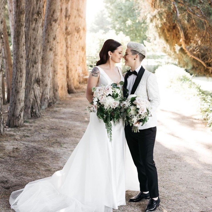 same sex black and white wedding outfit with blush bouquet