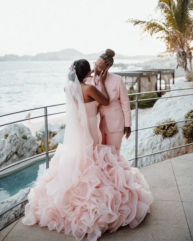two lesbian brides in pink ball gown and wedding suit