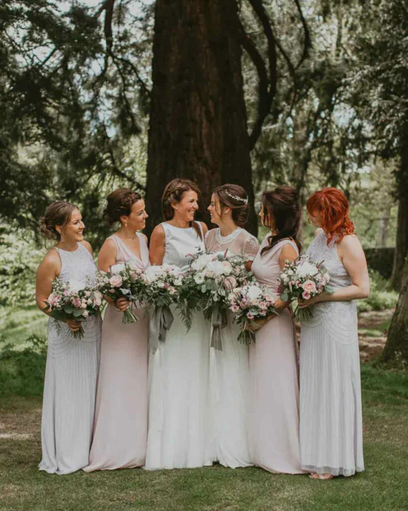 two lesbian brides with bridesmaids in pastel dresses