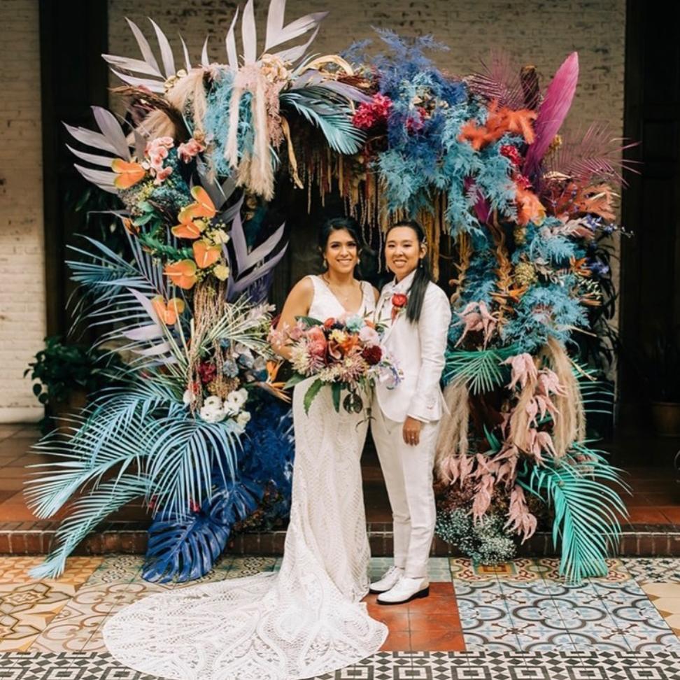 wedding ceremony lesbian wedding boho theme floral backdrop