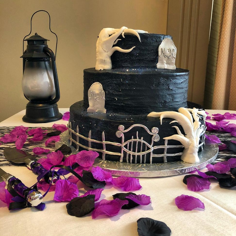 three tier Halloween wedding cake with floral arrangement