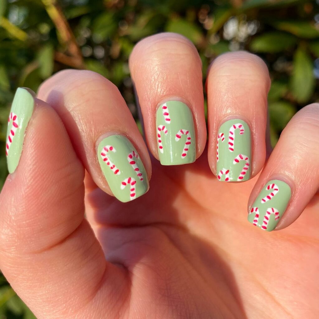 Minty green Christmas nails with candy cane accents