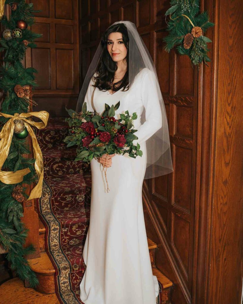 Simple Christmas bridal dress with red bouquet