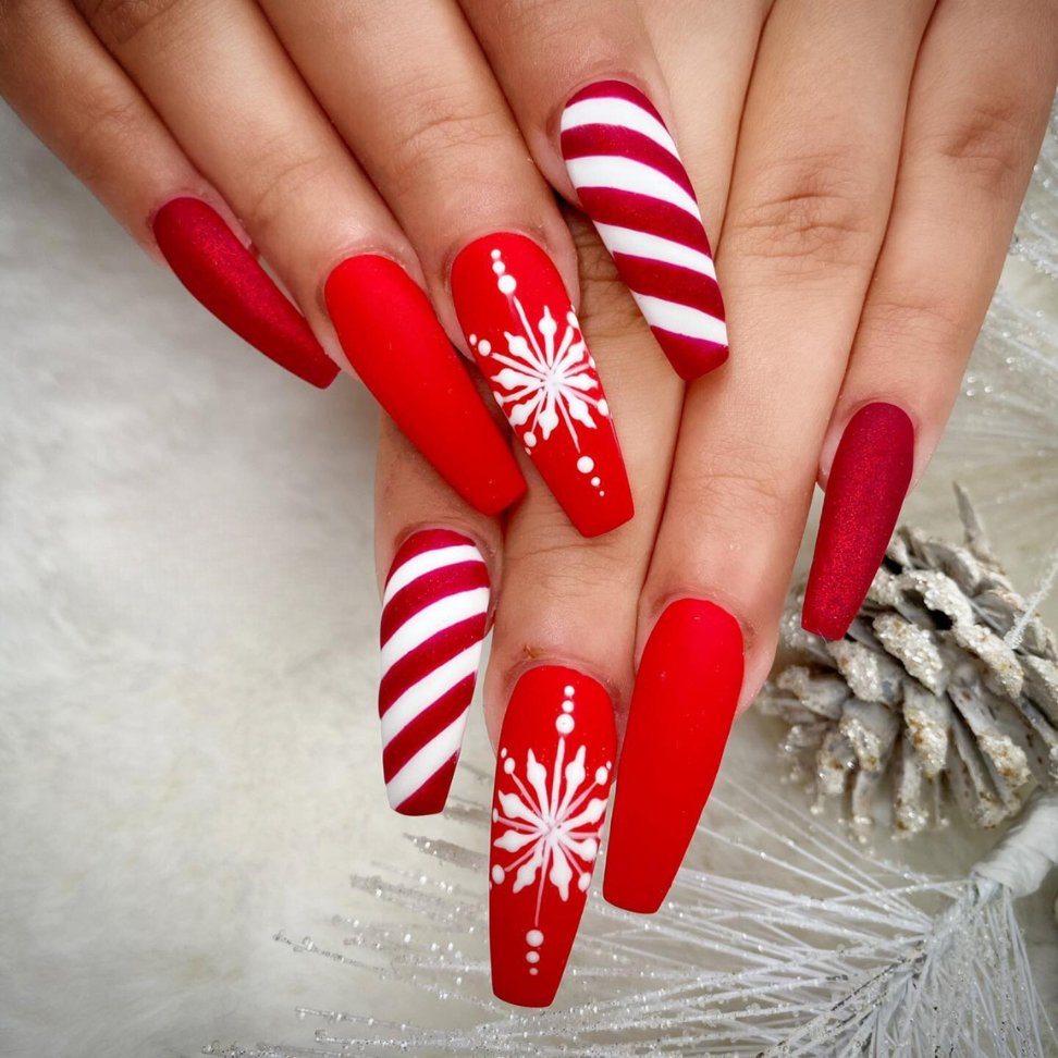 The vibrant red with crisp white stripes and snowflake Christmas nail designs