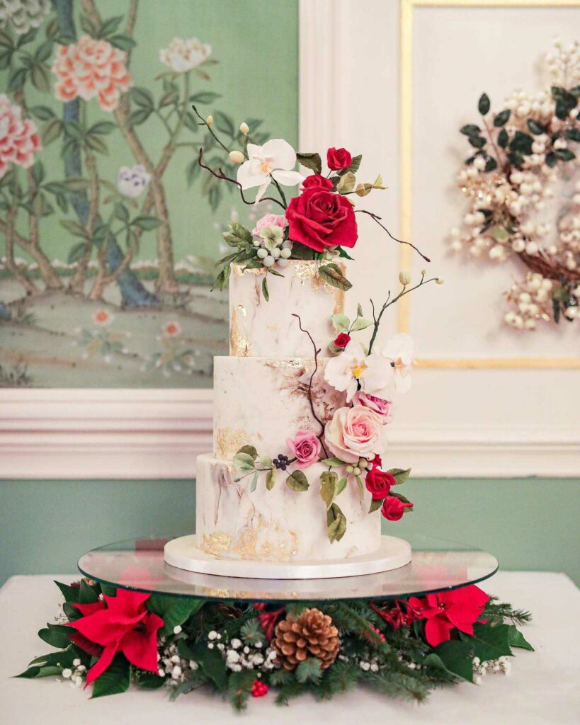 Winter floral wedding cake with gold Leaf and bold blossoms