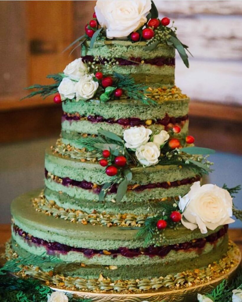 four tiered semi naked berry and white flowers winter wedding cake