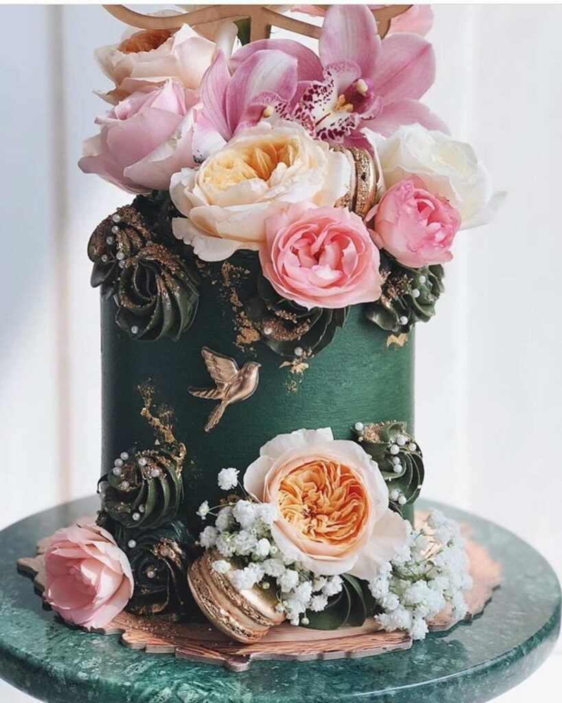 green and gold winter cake with fresh blooms and macarons