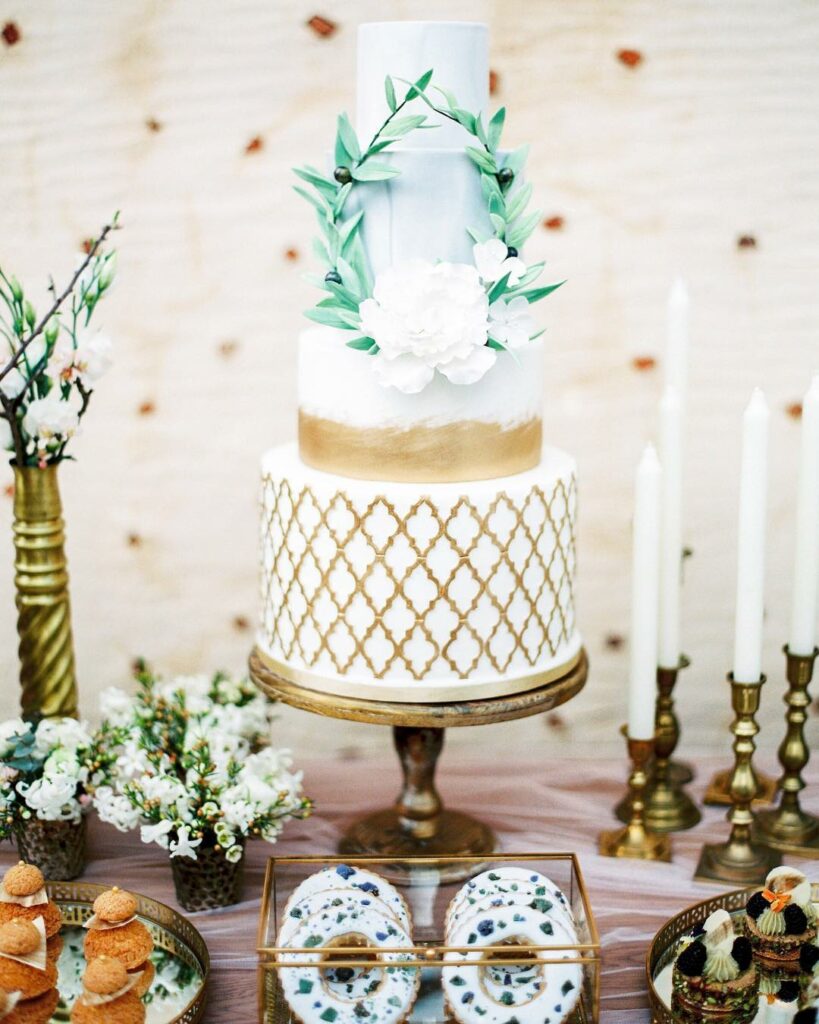 green laurel wreath winter and gilded quatrefoil pattern wedding cake