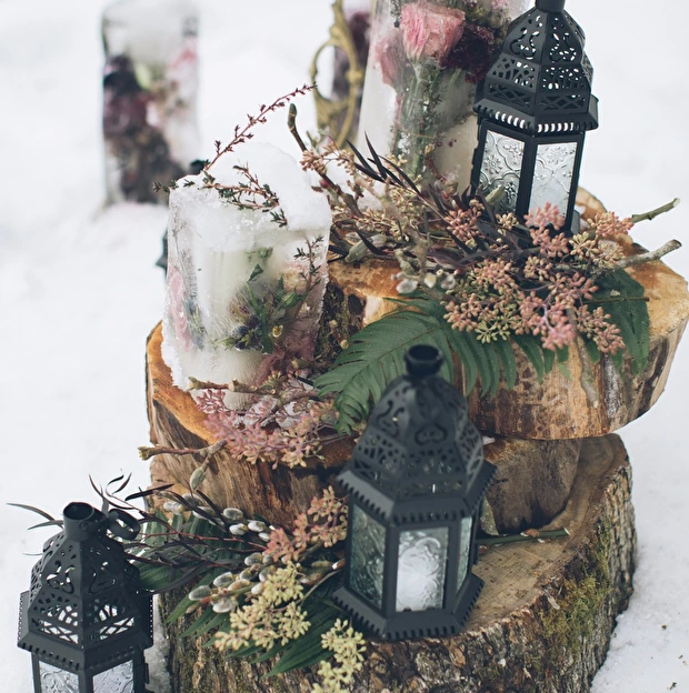 ice encased florals and rustic lanterns on wooden stumps Christmas winter wedding ideas