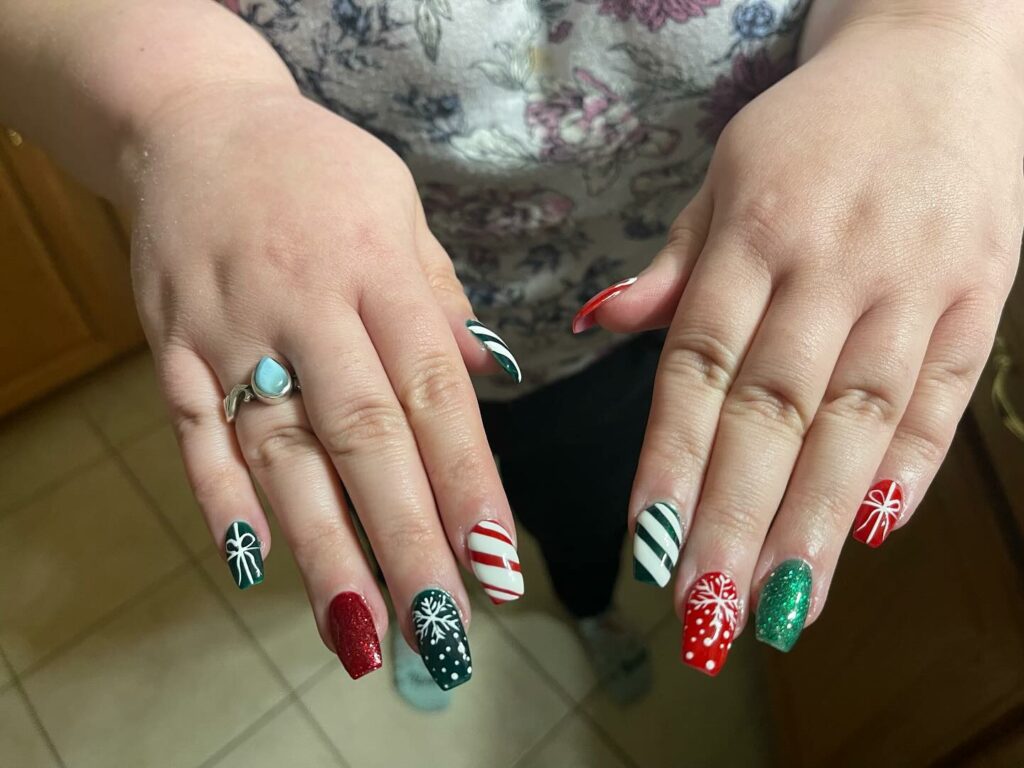 patterns and colors Christmas nails with mix of candy cane stripes snowflakes and sparkling red and green polishes