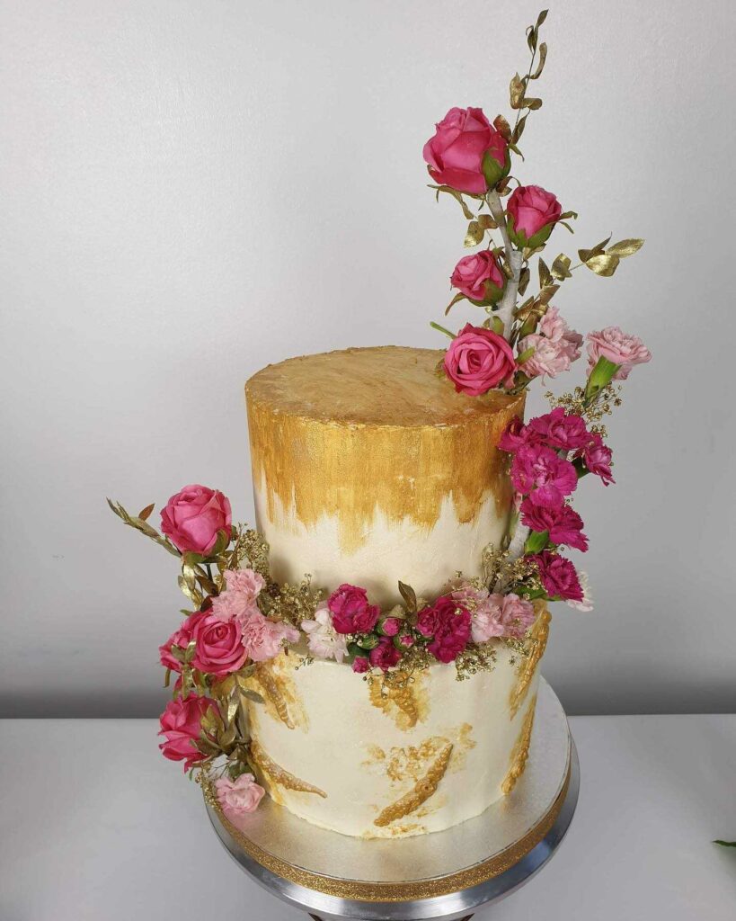 romantic white and gold winter buttercream wedding cake with fresh flowers