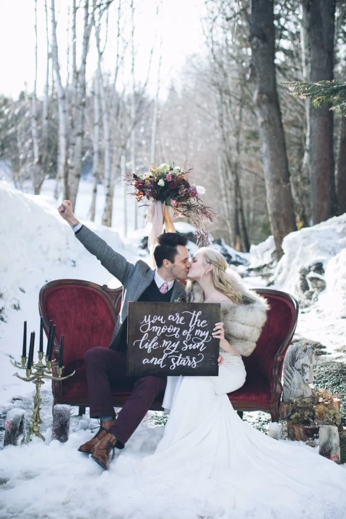 snowy backdrop the cozy vintage couch and the heartfelt sign winter fairytale wedding
