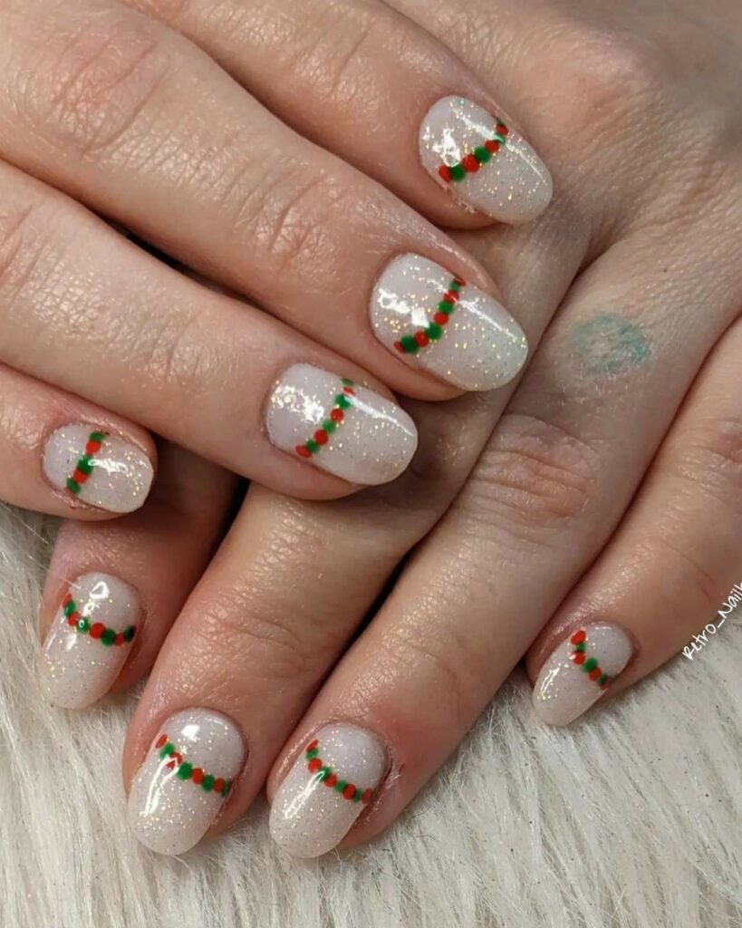 soft shimmering base and dainty holly berry accents Christmas theme winter nails