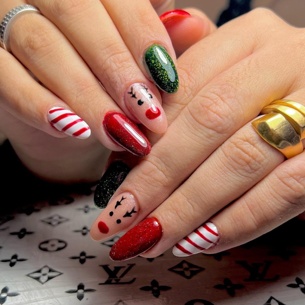the iconic reindeer alongside festive candy cane stripes and sparkling green and red Christmas nails art