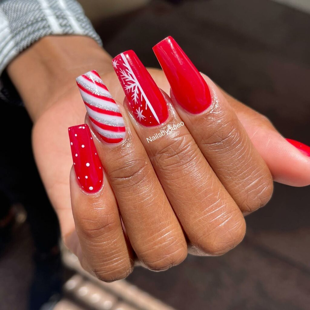 vibrant red color and the candy cane striped pattern Christmas nail art