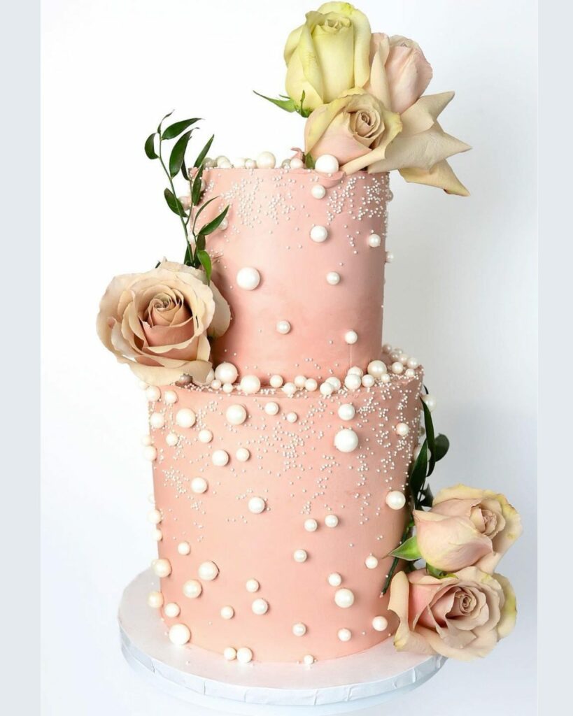 blooming blush wedding cake adorned with delicate roses and pearlescent accents