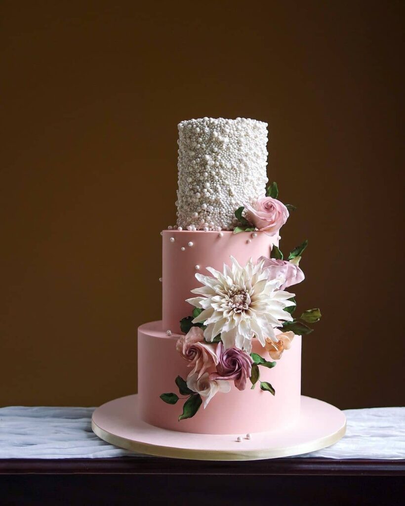 blushing texture chic wedding cake with floral elegance and pearled tier