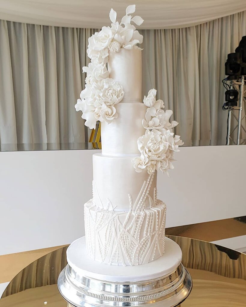 pearl wedding cake with sugar flowers and lace detailing