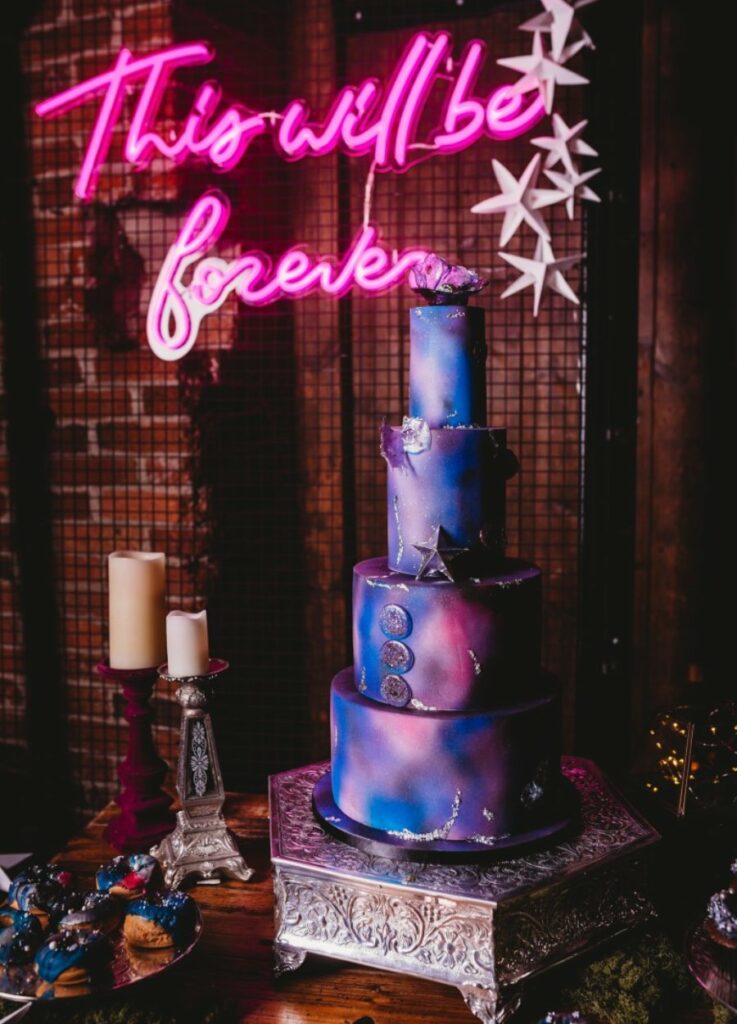 plum and navy wedding cake with neon sign